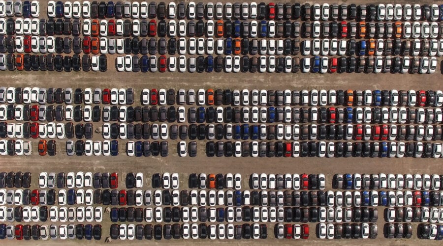 Vue aérienne d'un immense parking de stockage avec de nouvelles voitures. Les marques automobiles les plus fiables selon J.D. Power.