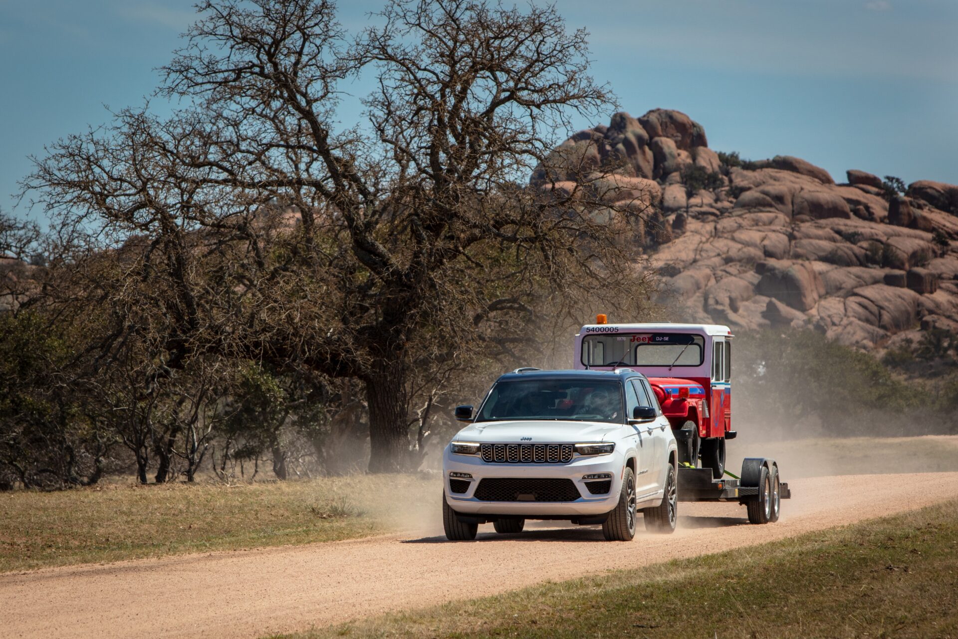 2024 Jeep Grand Cherokee Summit Reserve 4xe, avec une capacité de remorquage de 6,000-lb towing capacity, tirant Jeep DJ-5E electrique VUS de 1976