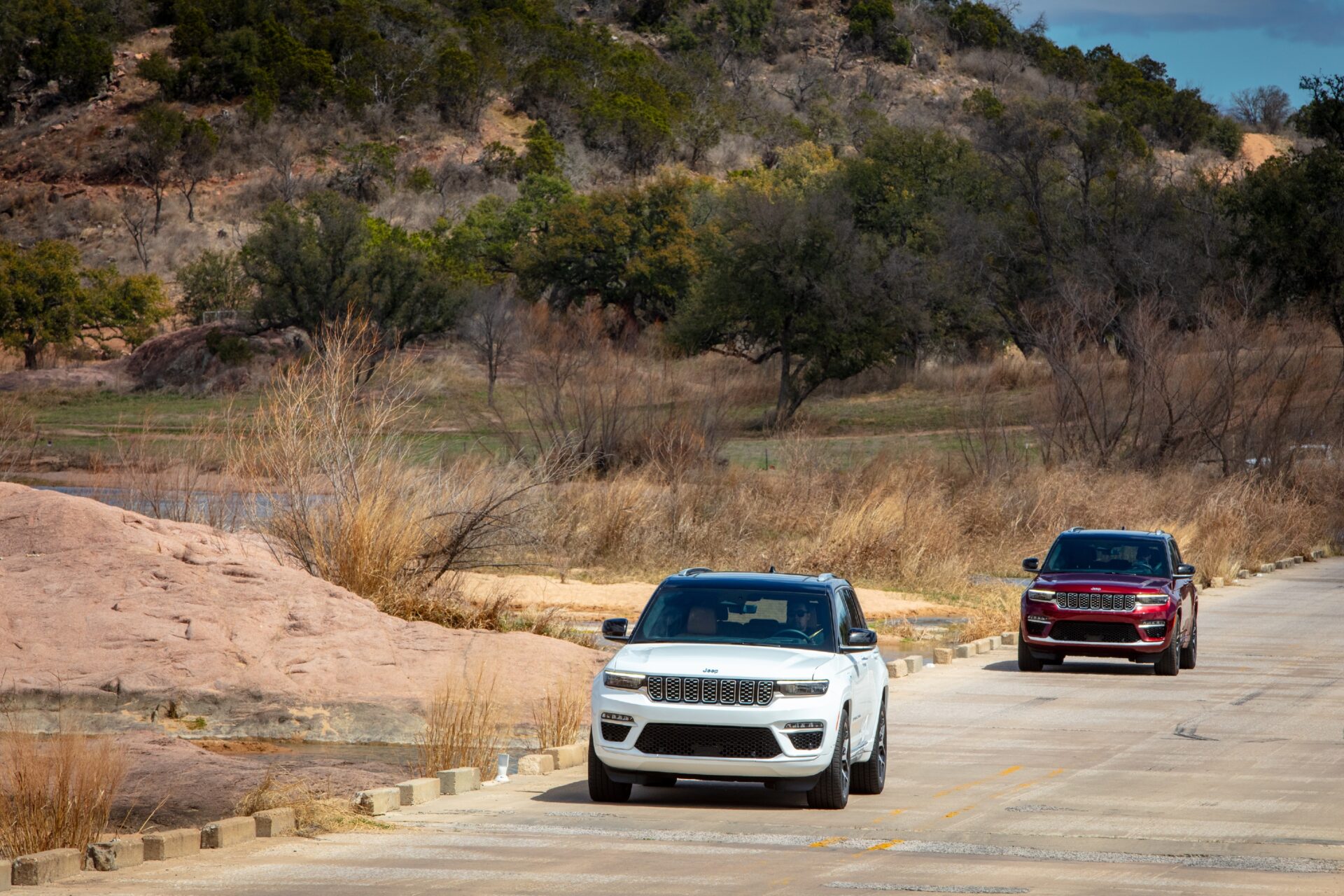 Deux Grand Cherokee 4Xe 2024 qui roulent et qui se suivent sur un pont passage à gué